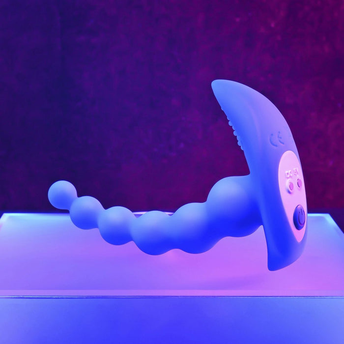 The Beaded Pleasure Remote Control Vibrating Anal Beads by Evolved Novelties are shown standing upright on a glowing surface with a purple background. This blue silicone toy, with its beaded design and curved, textured end, features a silky smooth body and control buttons on the front.