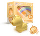 A small, yellow Bean Blossom Unicorn Shaped Licking Tongue Vibrator from Creative Conceptions is placed in front of its colorful packaging that features a rainbow design. The package includes the text "Unicorn," "Bean Blossom," and "Flirty Flutters of Fantasy." An orange sticker with the word "Exclusive" is visible in the corner of the image.