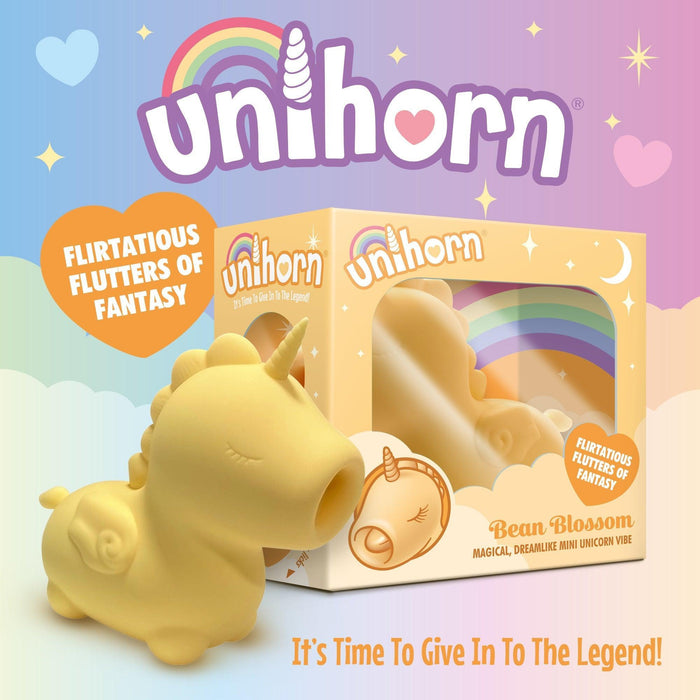 A small, yellow unicorn-themed silicone vibrator named "Bean Blossom Unicorn Shaped Licking Tongue Vibrator" by Creative Conceptions is displayed alongside its colorful box adorned with rainbow and star graphics. The waterproof packaging also features the slogans, "It's Time To Give in to The Legend" and "Flirtatious Flutters of Fantasy.