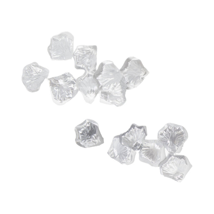 Small, clear crystals from the Beloved Vacation Lovin' Intimacy Kit are scattered on a white background, evoking the allure of sensual travel essentials.