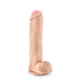 The Big John 11.5 Inch Dual Density Suction Cup Dildo in Vanilla by Blush features a realistic, skin-toned design with a veiny texture, detailed head, and attached testicles. It stands upright on any flat surface thanks to its secure suction cup base.