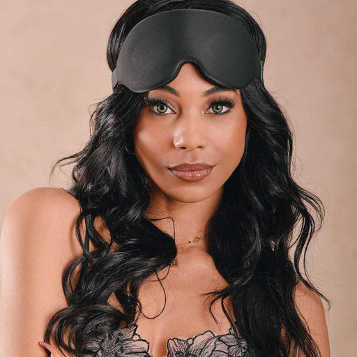 Woman ready for a restful night's sleep, confidently sporting a Sportsheets Blackout Blindfold with an adjustable elastic headband.