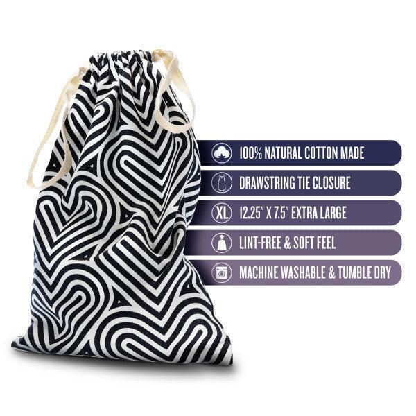 The Blush Bomba Black & White Hearts Sex Toy Storage Bag is displayed, featuring a striking geometric heart pattern. Adjacent icons and text highlight its features: crafted from 100% natural cotton, it is perfect for sex toy storage. The bag offers a drawstring closure and an extra-large size of 12.25" x 7.5". It boasts a lint-free and soft feel, and is both machine washable and tumble dry safe.
