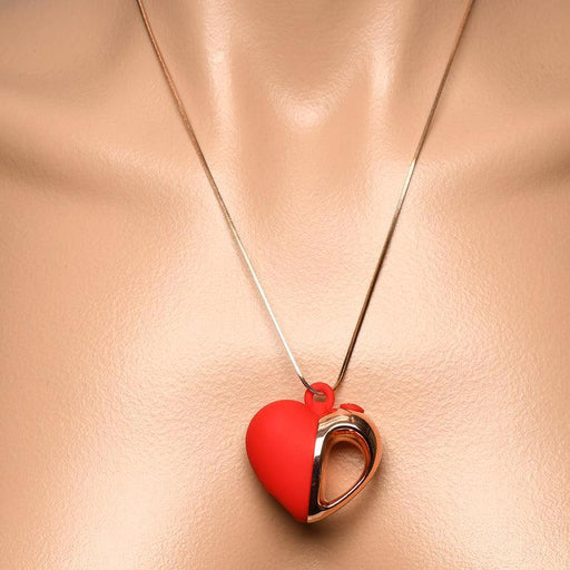 A close-up of a person’s neck wearing the Charmed Silicone Heart-Shaped Necklace Vibrator—a discreet gold chain with a red, metallic-accented heart pendant designed for stylish and subtle pleasure.