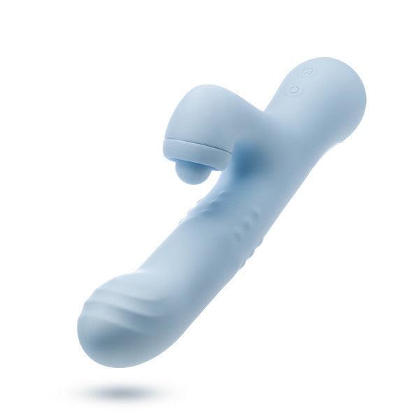 The Devin Clit Thumping G-Spot Rabbit with Shaft Rotation by Blush is a light blue silicone vibrator designed with a curved, ergonomic shape. It features a ribbed tip for G-spot stimulation and includes a secondary nodule near the base for dual stimulation. The device has two control buttons on its side and is presented on a plain white background.