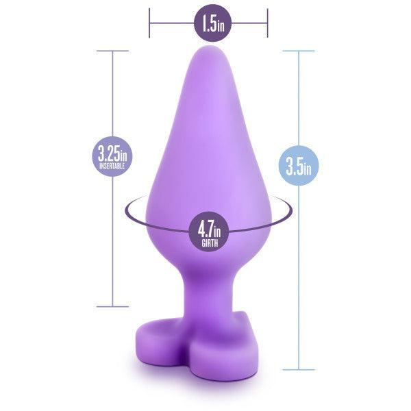 Introducing the Do Me Now Naughty Candy Heart Purple Butt Plug by Blush—a purple, cone-shaped silicone sex toy with a flared base that's perfect for anal beginners. This toy measures 1.5 inches at its widest point, 3.25 inches of insertable length, and has a total height of 3.5 inches with a girth measurement of 4.7 inches.