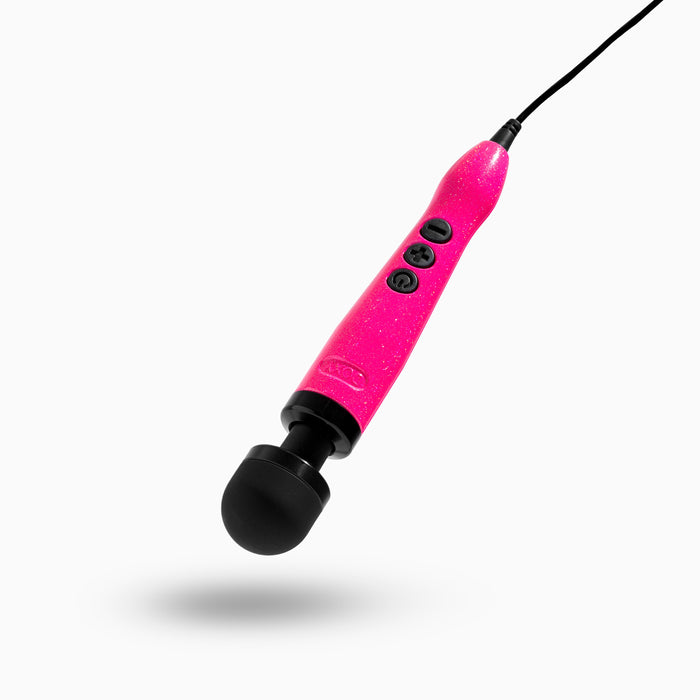 A handheld, hot pink electric massager with a black head and black buttons on the handle. The device, known as the Doxy Die Cast 3 Compact Wand Vibrator Hot Pink by Doxy, is a compact powerhouse plugged in with a black cord, ideal for delivering targeted intensity. The background is plain white.