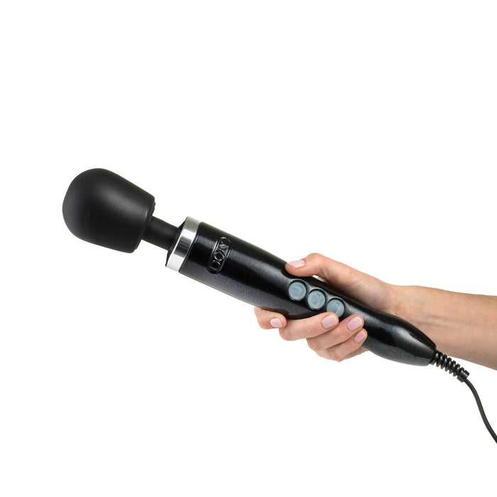 A hand holds the Doxy Die Cast Extra Powerful Wand Vibrator by Doxy, featuring a black, corded design and a large, round head. The massager has several control buttons on the handle, making it ideal for delivering deep rumbly vibrations.