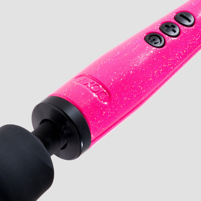 Close-up of the Doxy Die Cast Extra Powerful Wand Vibrator in hot pink against a white background. The wand features a black, rounded massage head designed for deep vibrations and three control buttons (mode, increase intensity, and decrease intensity) on the handle. The brand name "Doxy" is embossed near the buttons.