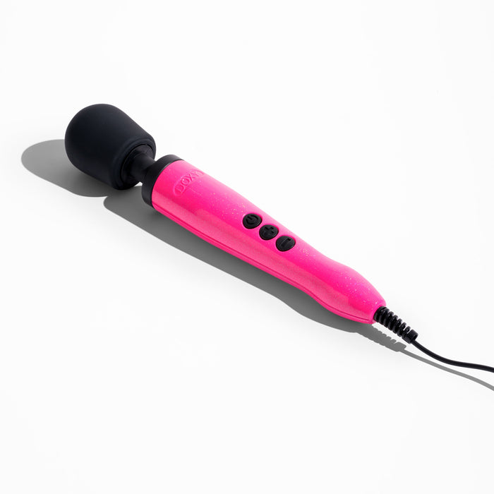 A Doxy Die Cast Extra Powerful Wand Vibrator - Hot Pink with a black, rounded head lies on a white surface. This Doxy device features a long handle with three black buttons and a cord attached at the bottom end, delivering deep rumbly vibrations for an intensely powerful wand massager experience.