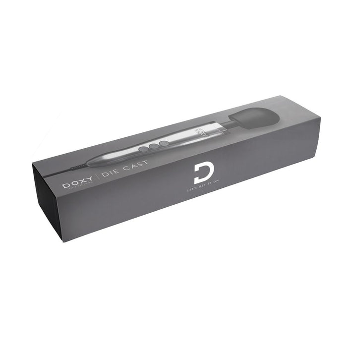 A sleek and predominantly gray product box showcasing the "Doxy Die Cast Extra Powerful Wand Vibrator - Silver." The packaging features a clear image of the luxurious massager with its large rounded head and silver handle adorned with three buttons. The brand's logo and slogan, "Let's Get It On," promising deep, rumbly vibrations are prominently displayed on the box.
