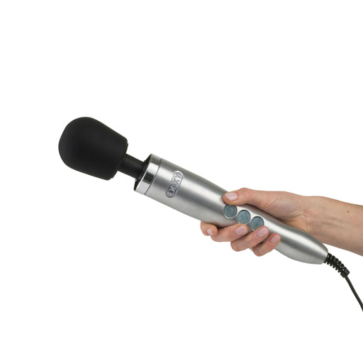A hand holding a Doxy Die Cast Extra Powerful Wand Vibrator - Silver, featuring a rounded head and a sleek design in silver and black. The device from the Doxy brand has multiple buttons on its handle for various settings and delivers deep rumbly vibrations. It is attached to a cord, indicating it is electrically powered. The background is plain white.