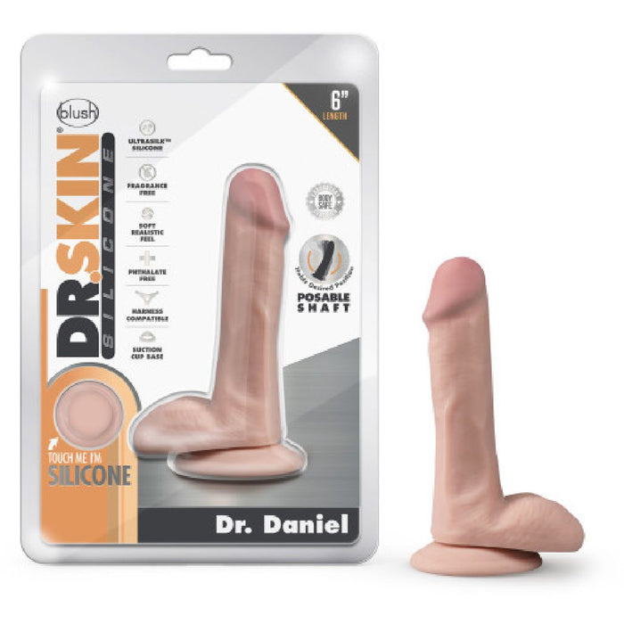 Packaging and product image of the "Blush Dr. Daniel 6 Inch Beginner Suction Cup Dildo - Vanilla." The packaging showcases a flesh-toned platinum cured silicone dildo with a suction base, labeled "Dr. Daniel." The product is displayed outside the packaging, standing upright on a flat surface.