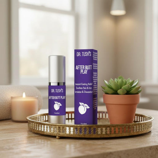 A bottle and box of Dr. Tush's After Butt Play Soothing Lotion rest on a gold tray beside a small potted succulent, set against a softly lit living room backdrop.