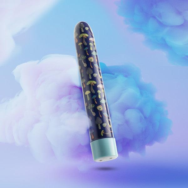 Against a dreamy, cloud-filled background, the blue cylindrical Dreamscape Powerful Extra Long Rechargeable Vibrator from Blush floats gracefully. The tube is adorned with colorful mushroom illustrations, enhancing its whimsical and ethereal vibe. This waterproof marvel is USB rechargeable for ultimate convenience and modern charm.