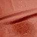 Close-up of water droplets on a textured red surface, forming a spreading stain—perfectly captured on the Dame Thro Soft Waterproof Sex Blanket, which is ultra-soft, machine washable, and fully waterproof.