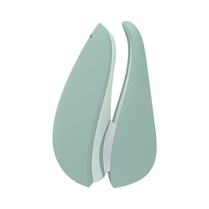 The Womanizer Liberty 2 is a mint green, travel-sized clitoral stimulator with a curved, modern design and Pleasure Air technology, shown standing upright against a white background.