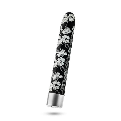 The Eden Black Floral Slim Beginner Bullet Vibrator by Blush is a small, elongated, cylindrical object with a smooth, rounded tip, decorated with a black and white floral design. This classic slimline vibrator features a silver base and boasts a sleek, modern design.