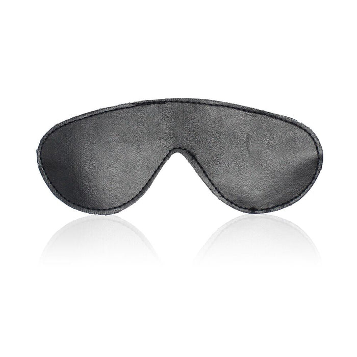 A black leather eye mask from Ple'sur's Everything Bondage 9 Piece Beginner's Bondage Kit lies flat against a white background, slightly reflecting at the bottom. Designed to fit comfortably around the eyes and provide full coverage for blocking out light, it makes a perfect addition to any starter set or bondage kit for those seeking sensory thrill.