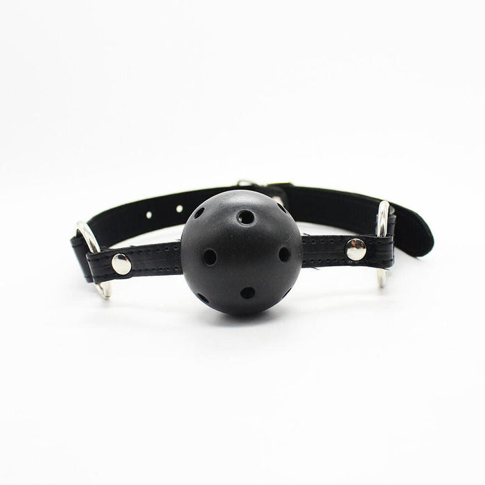Displayed against a plain white background is an item from the 'Everything Bondage 9 Piece Beginner's Bondage Kit - Black' by Ple'sur. Featured in the image is a black perforated ball gag equipped with adjustable leather straps and metal buckles, perfect for inclusion in a starter set or bondage kit. The gag is designed to fit comfortably in the mouth with ventilation holes, providing an exciting sensory thrill.
