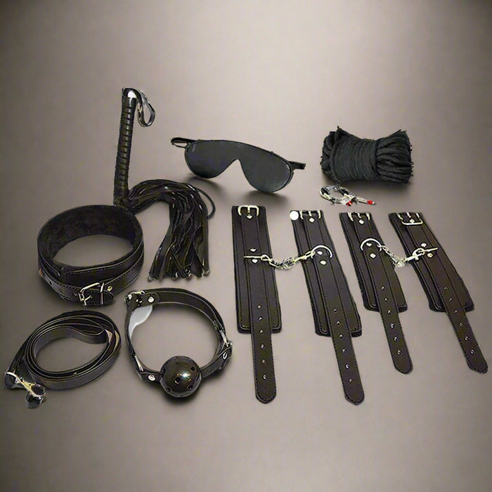 Introducing the Ple'sur Everything Bondage 9 Piece Beginner's Bondage Kit in Black. This sleek starter set features a whip, blindfold, rope, collar, gag, and wrist and ankle restraints. Perfectly designed for sensory thrill seekers, this elegant kit is beautifully arranged against a white background.