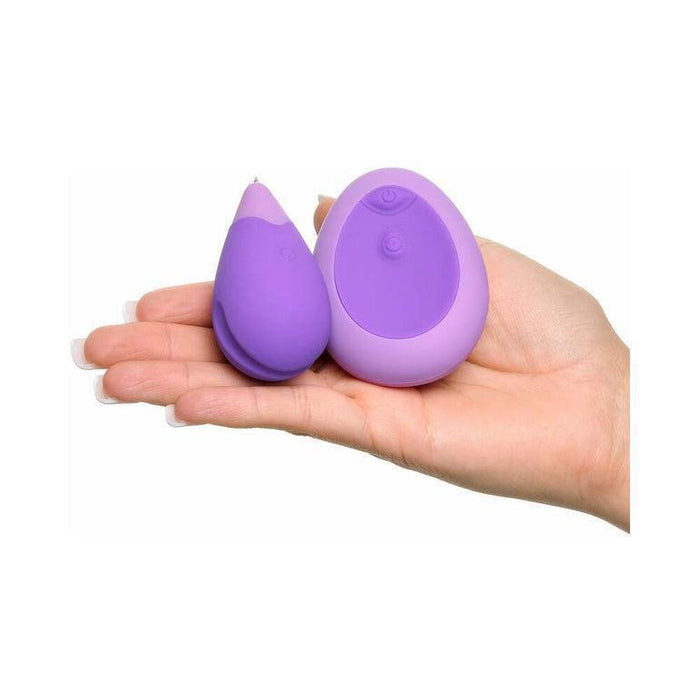 A hand holding a pair of purple Fantasy For Her Remote Controlled Kegel Exercisers by Pipedream Products, with one slightly larger than the other. Both devices have smooth, rounded surfaces and provide discreet vibration. They are compact enough to fit comfortably in the palm, making them ideal for pelvic floor workouts.