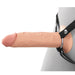 An image displays the Fantasy X-Tensions Elite Hollow 8 Inch Silicone Dildo & Strap-On Harness - Vanilla by Pipedream Products, with a realistic-feeling, flesh-toned dildo secured to a grey mannequin. The dildo is attached using a black harness that features metal rings and rivets for support. The surface of the dildo has a veined texture to enhance its realism.