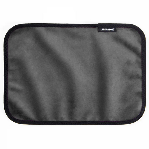 The Liberator Fascinator Toy Pad is a rectangular gray moisture-proof mini mat with rounded corners, black trim, and a small "Liberator" label in the upper right corner. The soft, smooth microfiber surface is likely machine-washable.