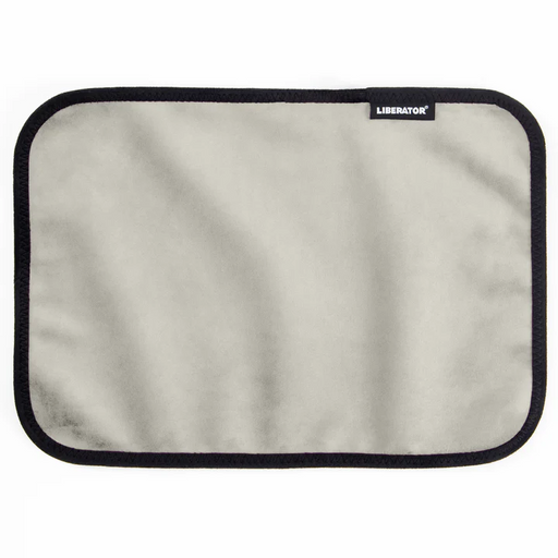 The Liberator Fascinator Toy Pad - Moisture-Proof Mini Mat features a rectangular, light gray, machine-washable fabric with rounded corners, a black border, and a small corner tag displaying the white "LIBERATOR" logo.