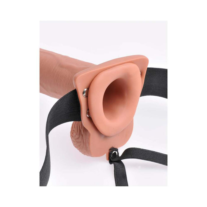 The Fetish Fantasy Vibrating 10 Inch Hollow Dildo & Strap-on Harness by Pipedream Products features a caramel-colored silicone harness attachment designed for sexual use. The dildo has a flesh-like texture and measures 10 inches in length, making it ideal for individuals experiencing erectile dysfunction. It is connected to adjustable black straps and is presented against a plain white background.
