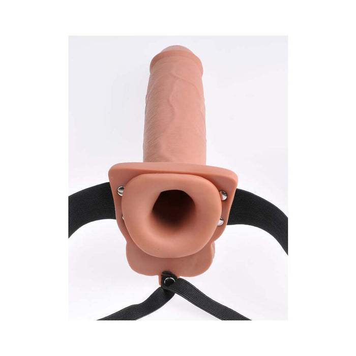 The Fetish Fantasy Vibrating 10 Inch Hollow Dildo & Strap-on Harness - Caramel by Pipedream Products is displayed against a white background. This realistic, caramel-toned strap-on dildo features detailed veins and a flared base, designed for attachment to the adjustable black straps of the harness for secure wearing. Ideal for those experiencing erectile dysfunction, this product ensures comfort and stability with its thoughtfully crafted design.