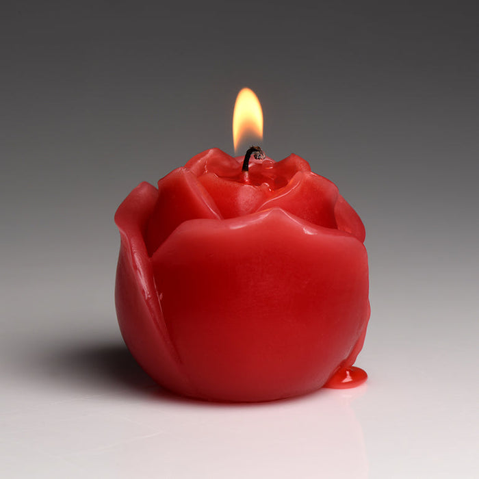 The Flaming Rose Drip Candle, a striking red rose-shaped candle with a gentle flame and pooling wax at its base, is perfect for exploring erotic sensations or wax play, shown against a neutral gray background.