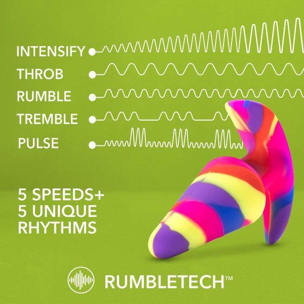 A vibrant, multicolored, abstract-shaped object set against a green backdrop features text that highlights its capabilities: "INTENSIFY, THROB, RUMBLE, TREMBLE, PULSE - 5 Speeds + 5 Unique Vibration Patterns." This butt plug is crafted from premium platinum-cured silicone and is perfect for beginners. At the bottom, the RumbleTech logo is prominently displayed. The product is called "Free Spirit Vibrating 10 Function Beginner Silicone Butt Plug" by Blush.