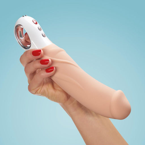 A hand with red nail polish holds the Fun Factory Big Boss Thick Vibrator in Vanilla, a beige-colored, phallic-shaped sex toy made of medical-grade silicone against a blue background. This large vibrator from Fun Factory features a white handle with buttons, designed for G-spot stimulation.