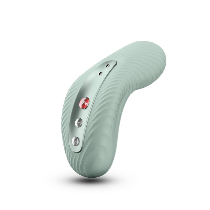 A sage green Fun Factory Laya 3 Lay On Humping Vibrator, ergonomically designed and crafted from body-safe silicone with a textured surface. The device features three metallic buttons, including a red power button. It stands upright, casting a shadow beneath on the plain white background.