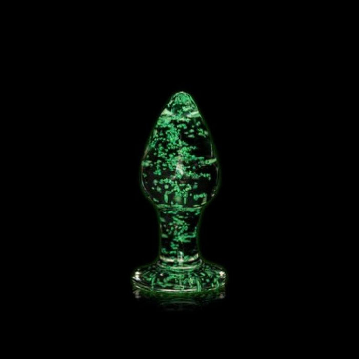 A glowing green Shots borosilicate glass object with an intricate texture, shaped like a narrow bulb with a wide base, set against a dark background.
