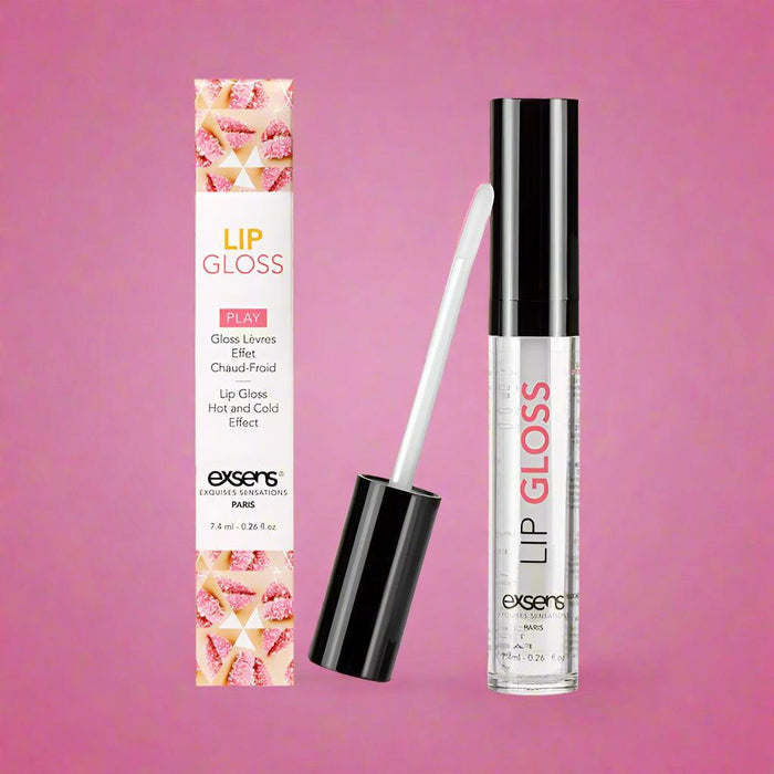Image of Exsens Hot Kiss Arousal Lip Gloss - Strawberry Flavored with a warming sensation. The product includes a box and an open tube of lip gloss with a wand applicator. The box features the product name, description, and decorative elements, while the clear tube showcases the body-safe gloss.
