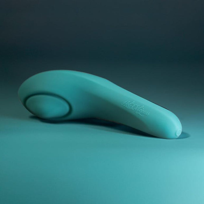 The Hot Octopuss Pulse Queen Oscillating Waterproof Vibrator, a teal, sleek, and modern handheld massage device featuring PulsePlate Technology, is lying on a surface with a gradient background. The handle boasts subtle Hot Octopuss branding, and the device has a rounded, ergonomic design crafted from premium silicone. The overall aesthetic is clean and minimalistic.