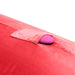 A close-up of the Liberator Humphrey Pillow-Style Sex Toy Mount in bright pink with a small pocket, partially holding a pink oval object, set against a white background.
