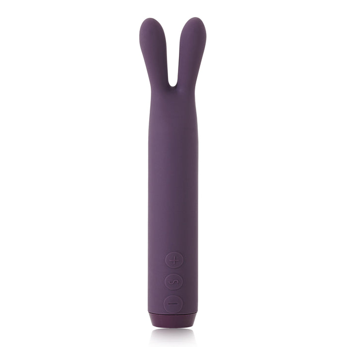 The Je Joue Powerful Bullet with Flexible Rabbit Ears - Purple by Je Joue is a sleek, cylindrical silicone rabbit vibrator featuring two flexible, rabbit ear-like appendages at the top. This rechargeable toy offers rumbly vibrations and has three buttons on its front side marked with plus, minus, and power symbols.
