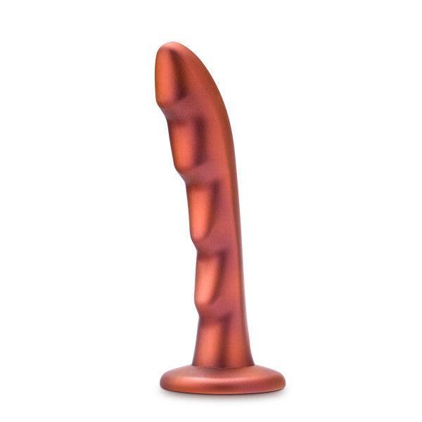 A bronze-colored Jealousy 7 Inch Rippled Silicone Dildo by Blush, featuring a ribbed and elongated design with a flat base for prostate stimulation, stands vertically against a white background.