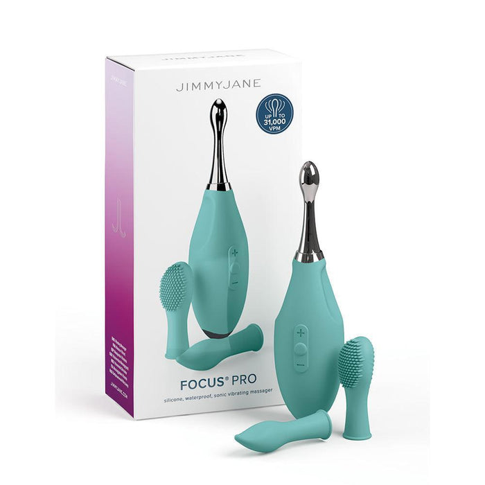 The image shows the Jimmyjane Focus Pro Pinpoint Tip Clitoral Vibrator by Pipedream Products, a silicone, waterproof massager with powerful sonic vibrations in teal. The packaging box and two interchangeable head attachments are visible: one smooth and one textured with bristles.