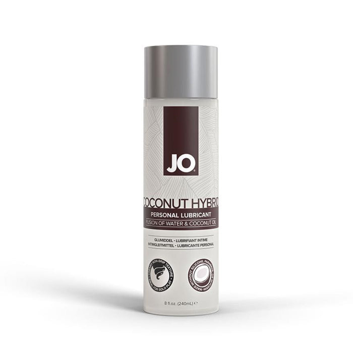 A bottle of System Jo's JO Coconut Hybrid Original Lubricant, boasting a paraben-free, water-based formula and featuring a silver cap, is displayed. The label, adorned with white and brown accents, prominently showcases the product name "Coconut Hybrid" and details its unique blend of water and coconut oil. The bottle has an 8 fl. oz. (240 ml) capacity.