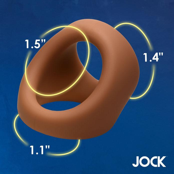 The JOCK Silicone Cock & Ball Ring Medium Skin Tone features three circular openings (1.5", 1.4", and 1.1") for customizable support. The product is brown, set against a blue background with "JOCK" in the bottom right corner.
