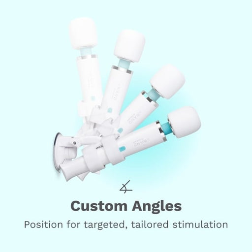 Four white Le Wand Adjustable Hands-Free Vibrator Mounts with suction cups are attached to a surface, each angled differently. Text below reads: “Custom Angles. Position for targeted, tailored stimulation.”.