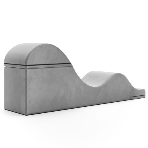 The Liberator Aria Flip Chaise Sex Lounger is a gray, modern, convertible bench with a wave-like design and smooth surface, discreetly blending into the bedroom against a plain white background.