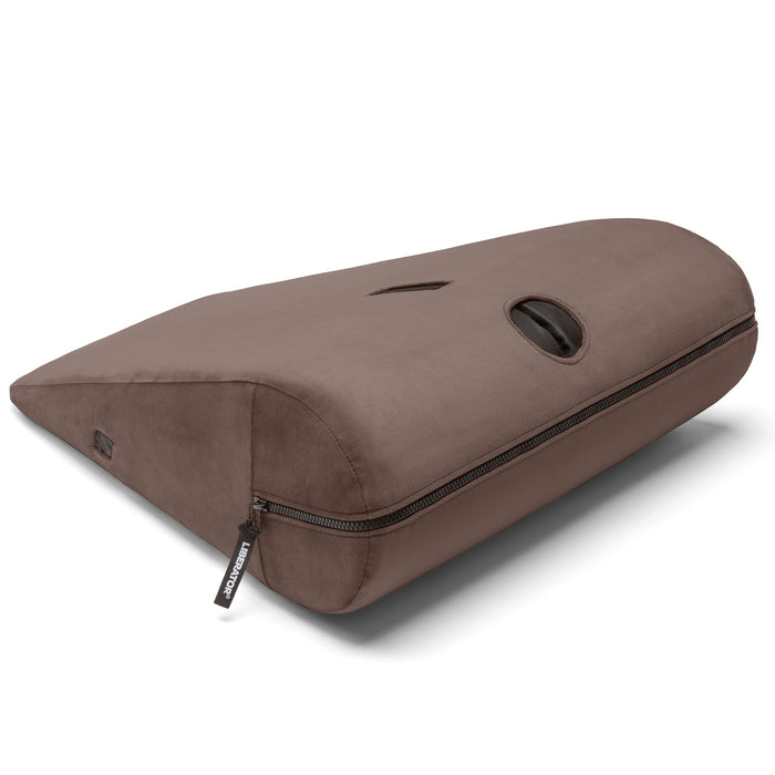 The Liberator Axis Magic Wand Hands-Free Sex Toy Mount is a brown, wedge-shaped pillow with a zipper and oval opening on top, designed for ergonomic support and hands-free use of the Magic Wand.