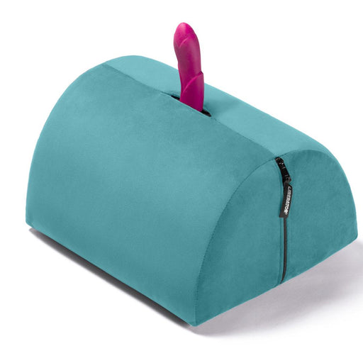 The Liberator BonBon Rideable Sex Toy Mount is a teal, semi-cylindrical cushion with a zippered side and an opening on top to hold your favorite toy upright for hands-free play.
