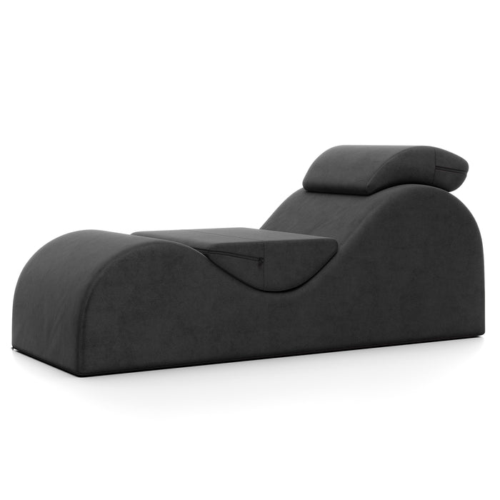 The Liberator Esse Sex Lounger is a modern black ergonomic chair featuring a curvy design and an attached headrest, displayed against a plain white background.