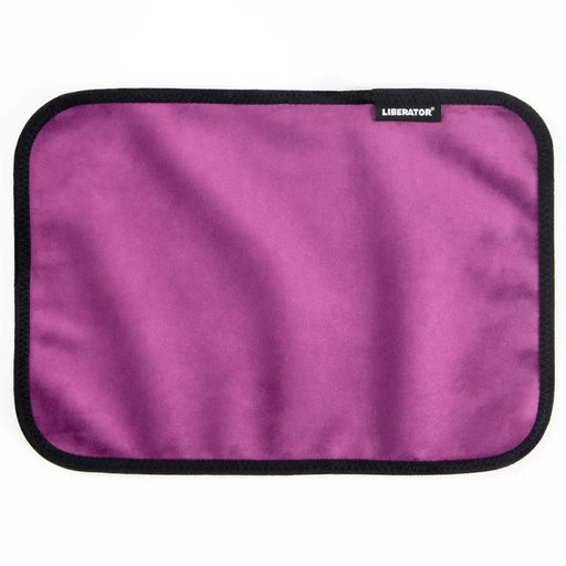 The Liberator Fascinator Toy Pad is a rectangular purple mini mat with black trim and a small "LIBERATOR" label in the top right corner, shown flat on a white background. This moisture-proof pad is machine-washable for easy cleaning.